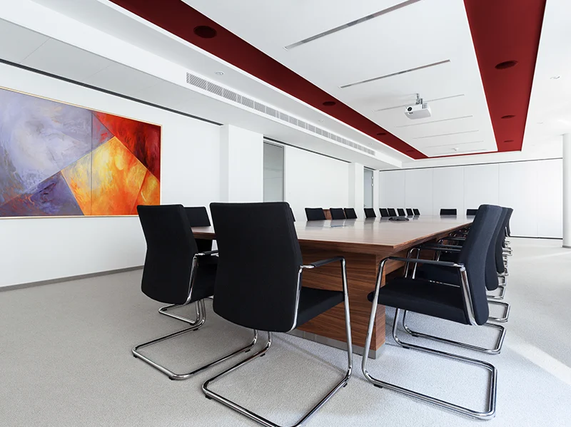 Corporate executive boardroom with long table and modern art